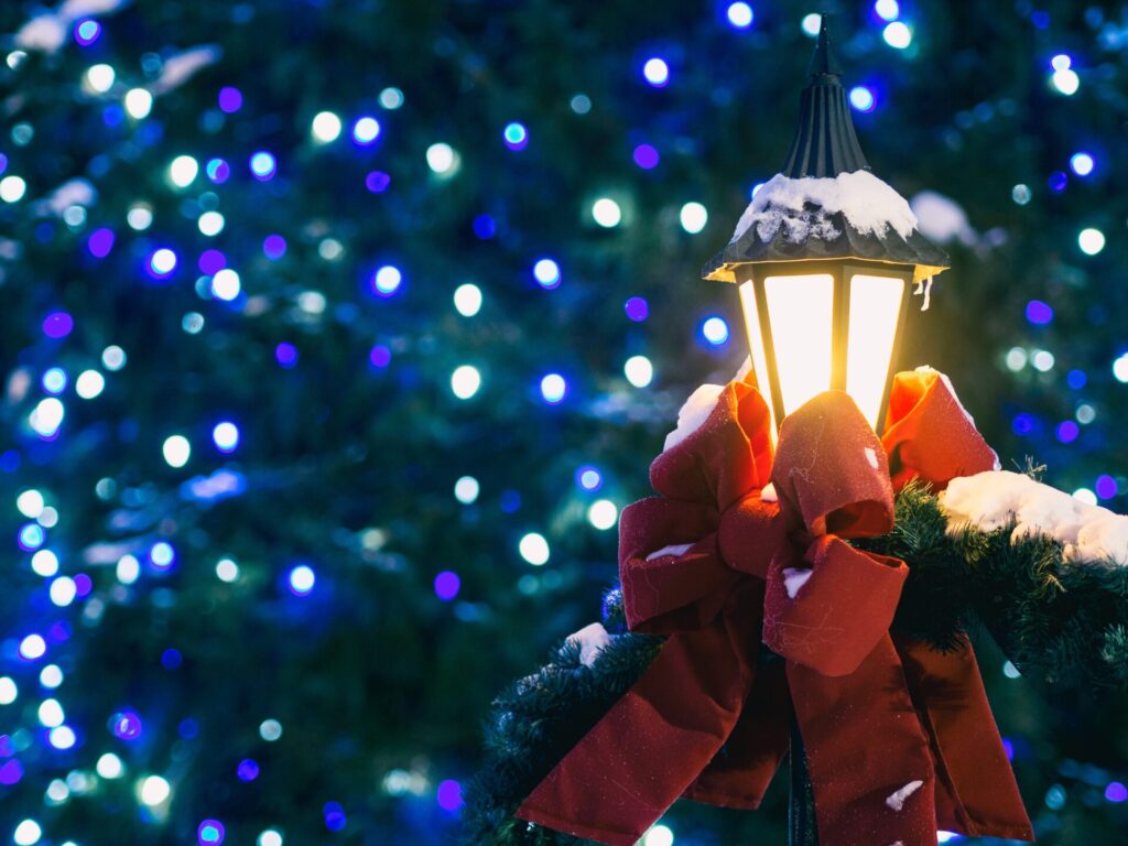 クリスマスイルミネーションの前で輝くリボンをかけたランプ