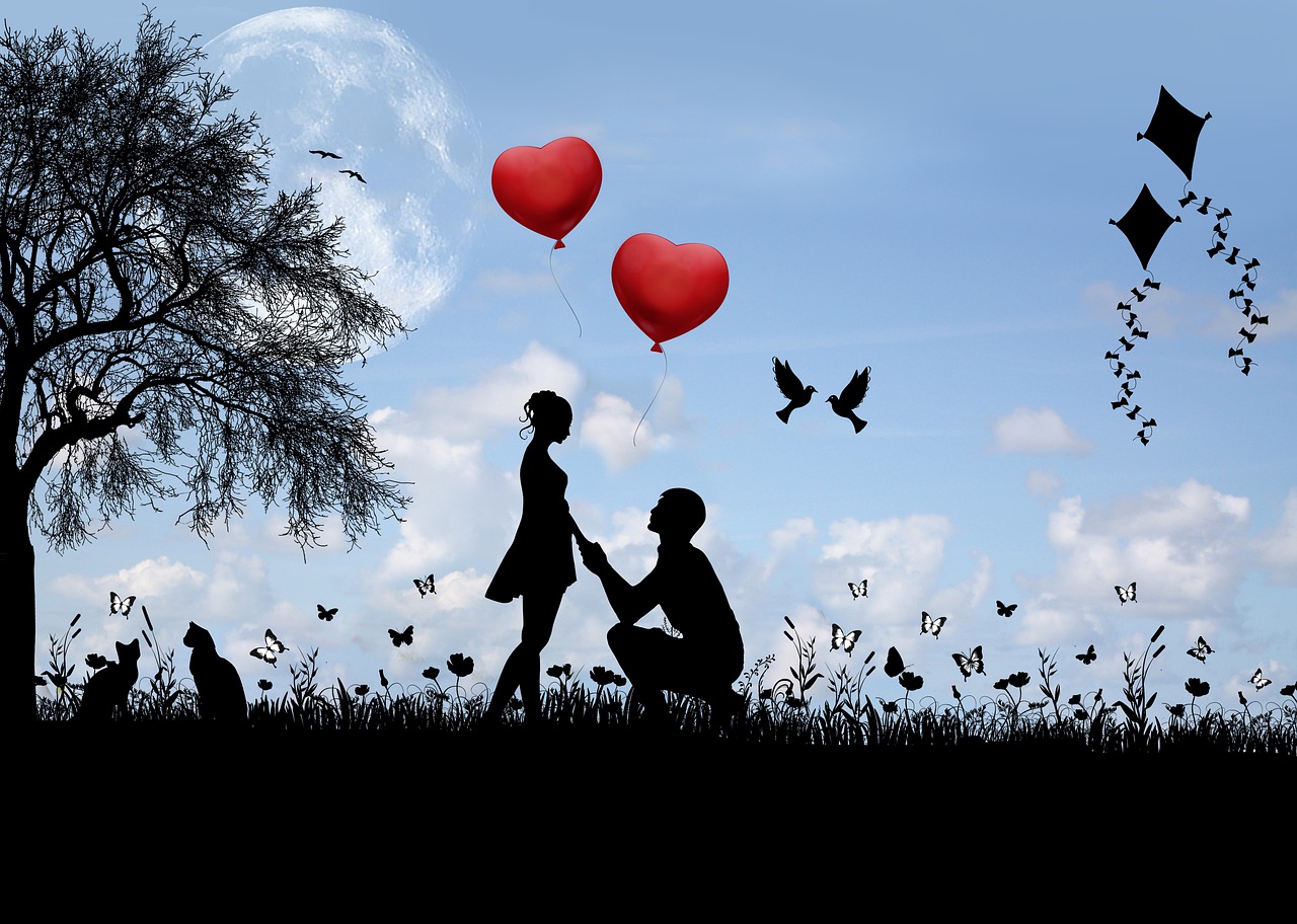 空に赤いハートの風船が浮かぶ屋外で男の子が女の子の前に膝まづきプロポーズしているシーン
