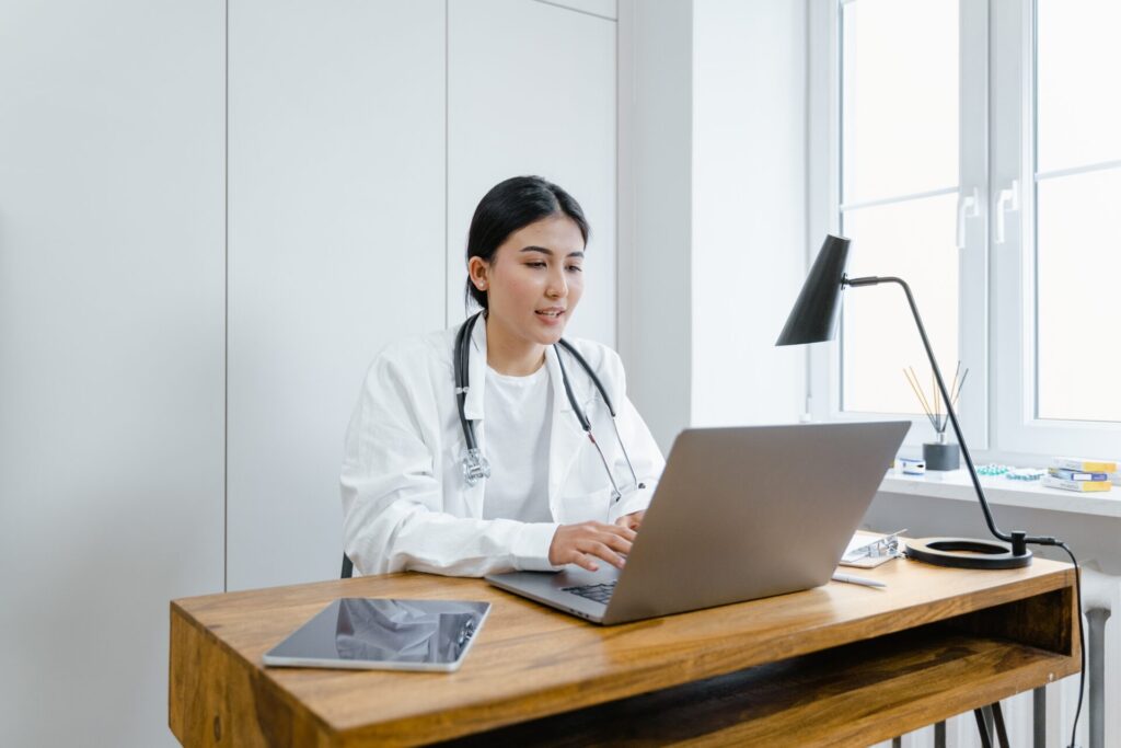 デスクでパソコンを前にオンライン診療をする女性医師