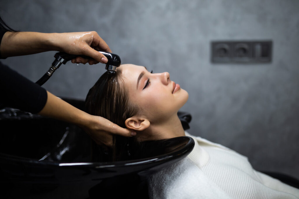 美容院で髪を洗われている女性の横顔
