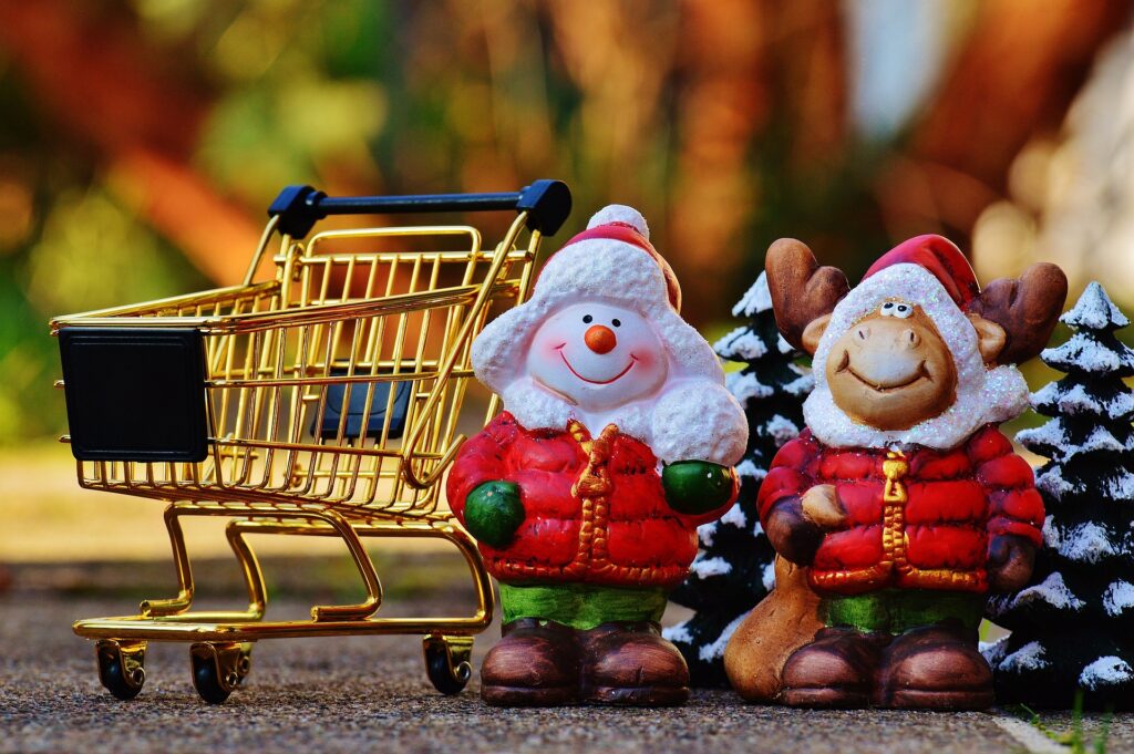 ショッピングカートの横に冬服を着たお人形とクリスマスツリー