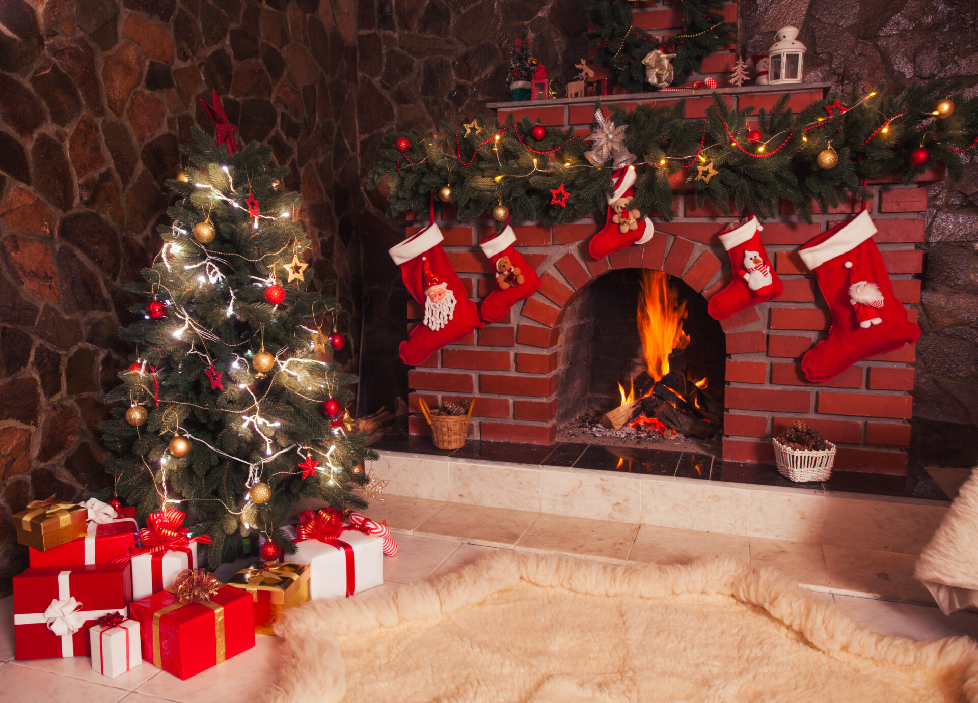 暖炉前に飾られたクリスマスツリーやプレゼントとソックス