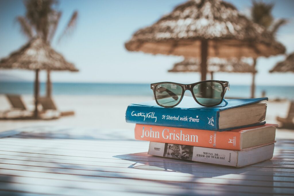 海辺のパラソルと本とサングラス