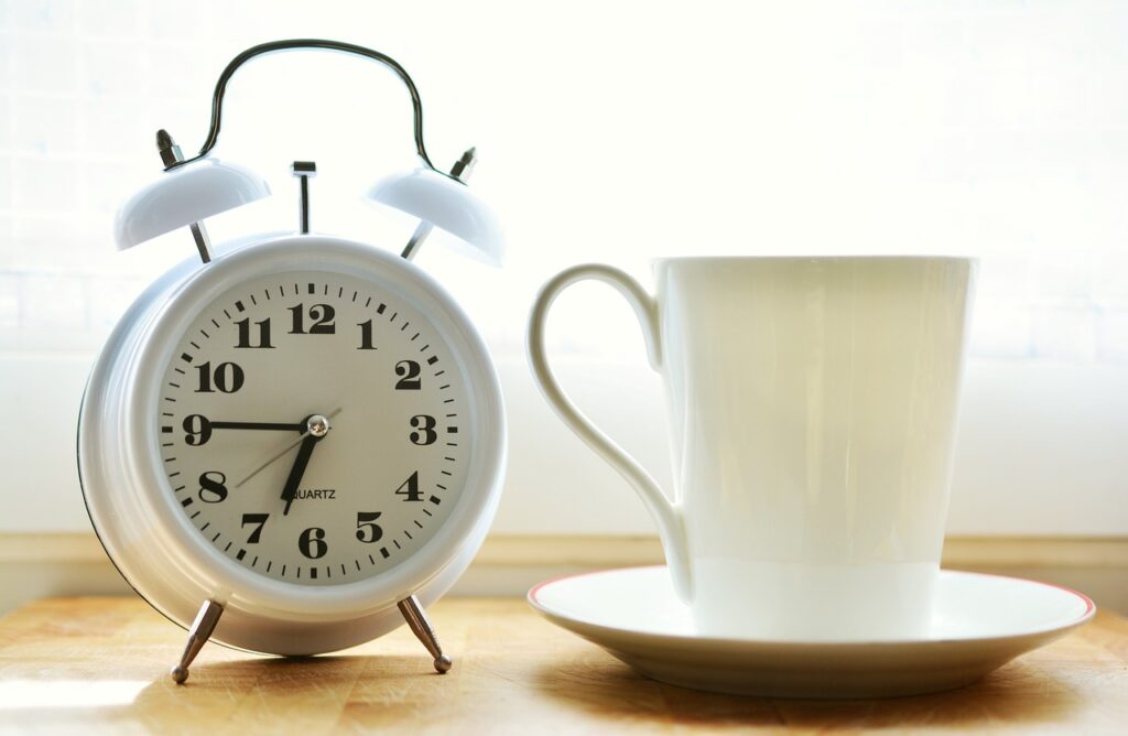 白い時計とコーヒーカップ